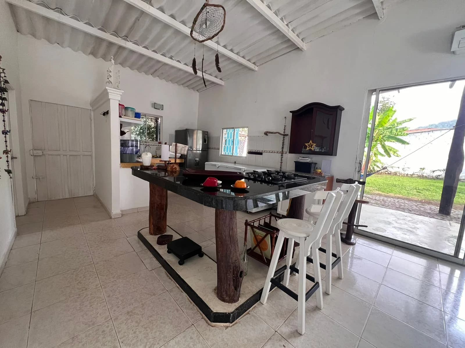 Cocina equipada con isla y estufa de gas en Casa Mahatma