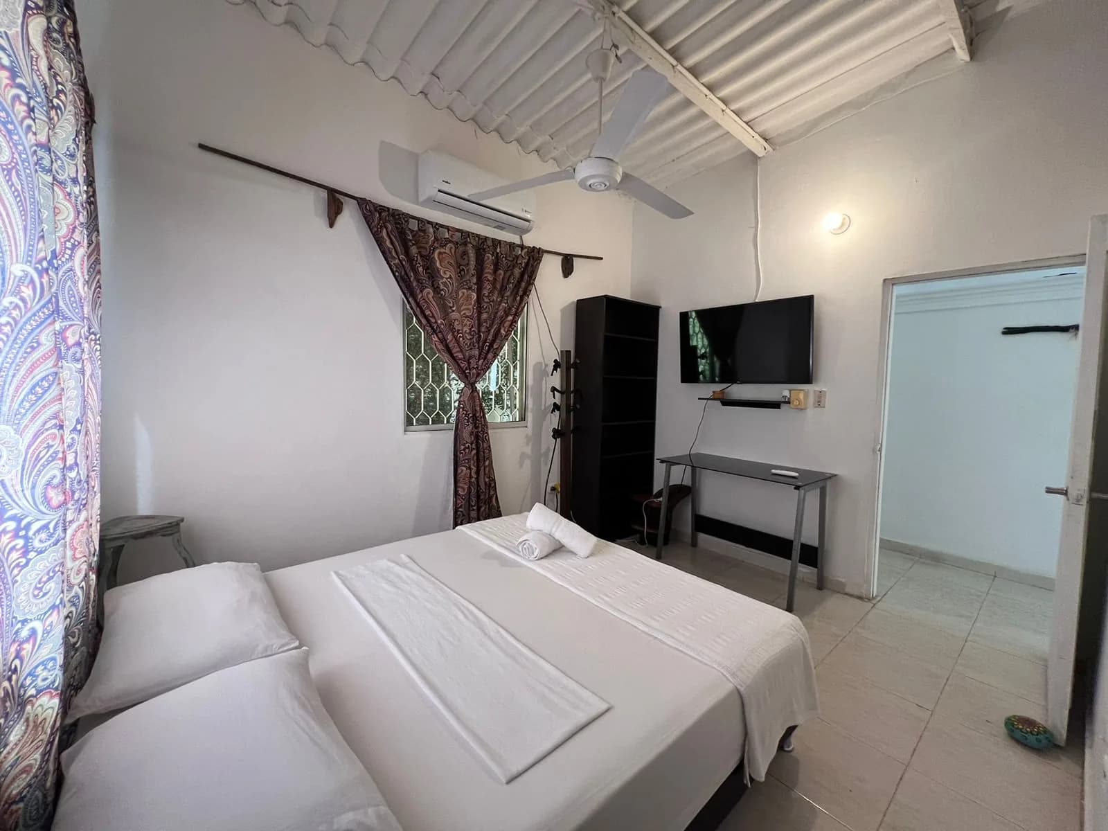 Habitación de Casa Mahatma con aire acondicionado y televisor