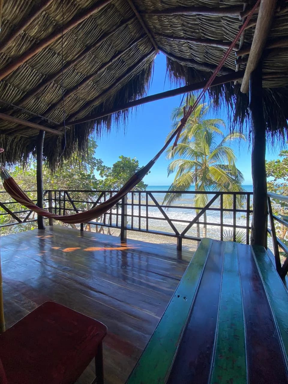 Hamaca en la terraza de madera de Casa del Mar, frente a las palmeras y el mar Caribe