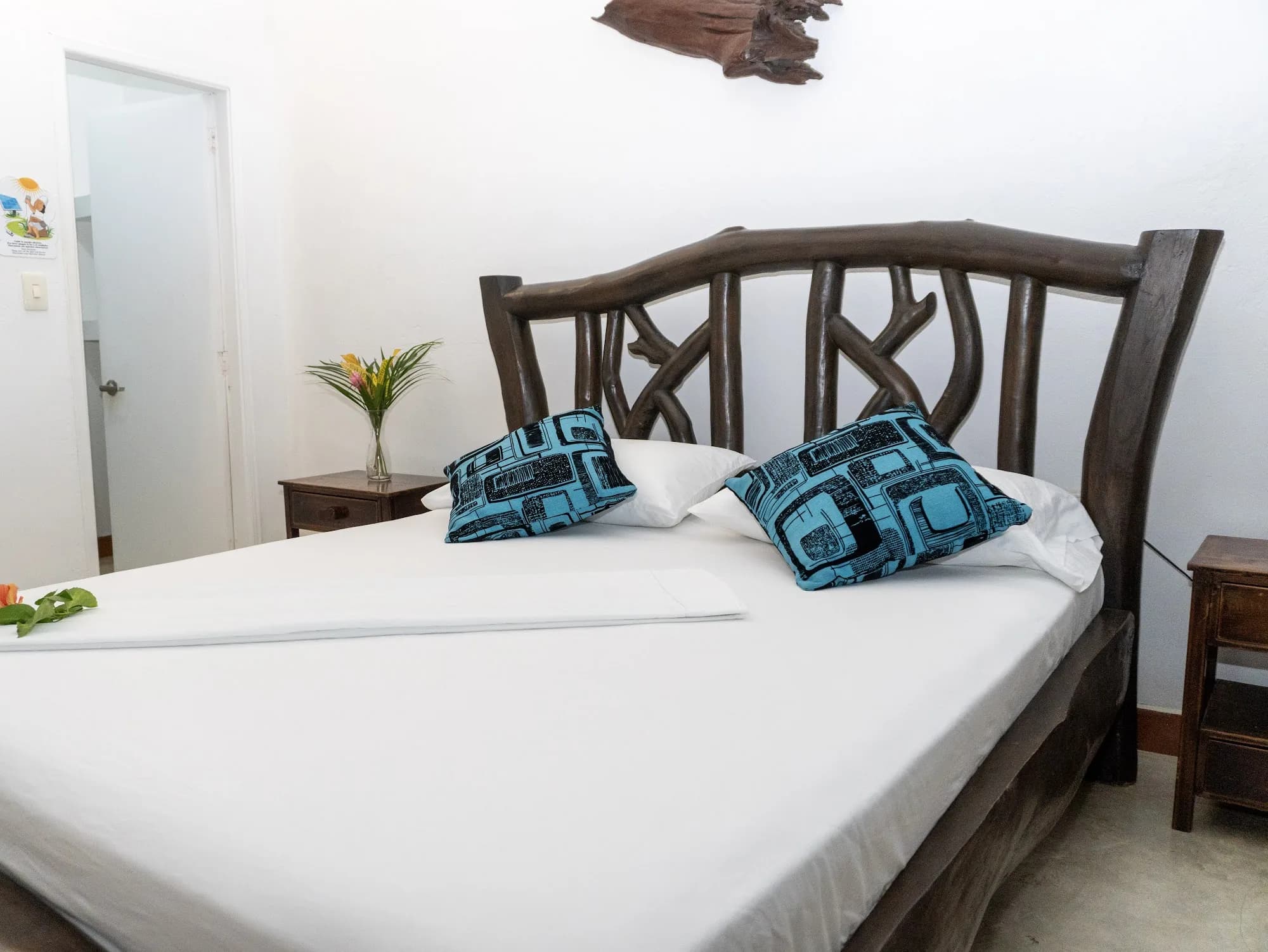 Detalle de la cama de la Casa Indígena con cojines de tejido azul