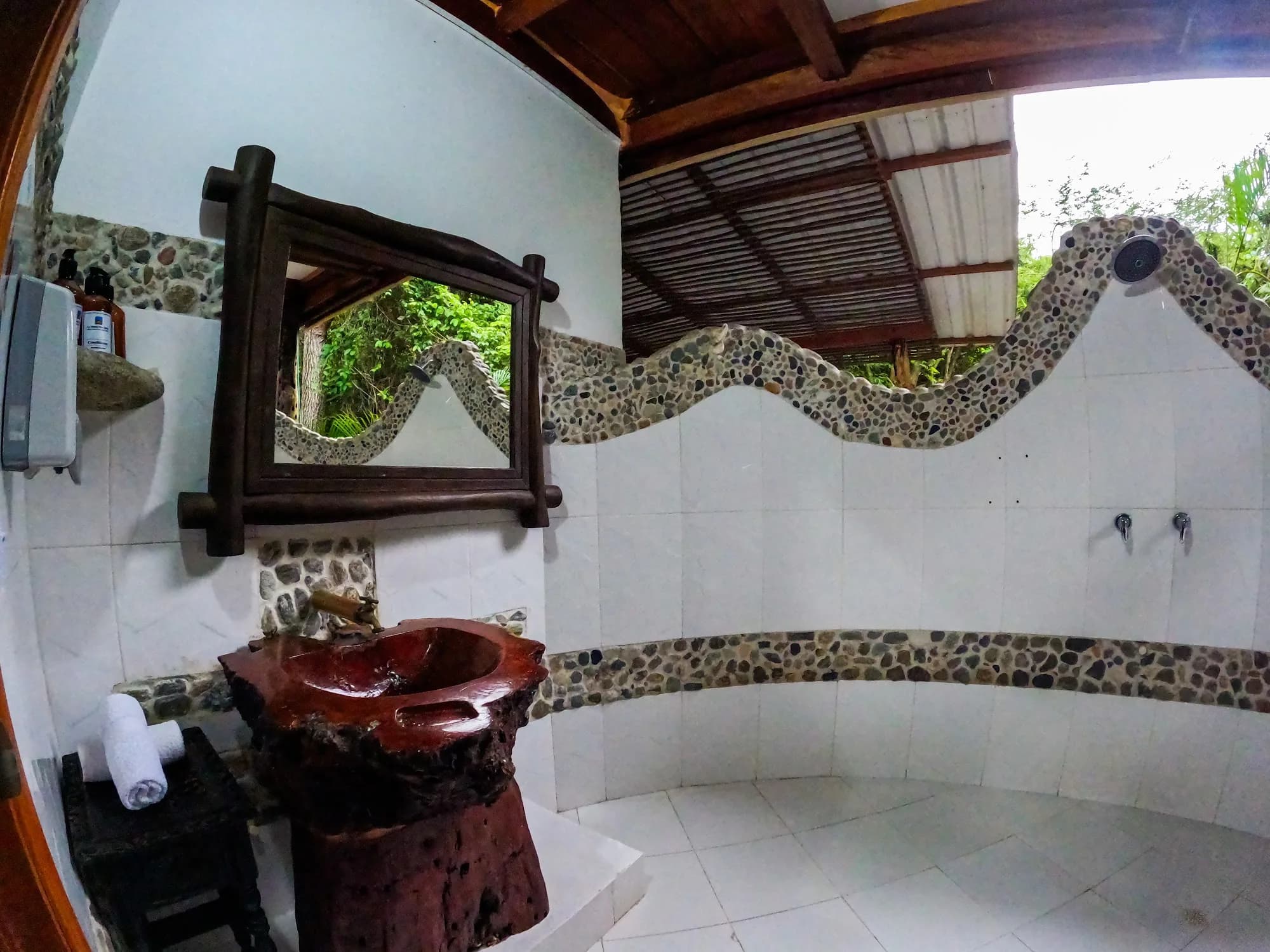 Baño privado de la habitación Higuerón, con lavamanos tallado en madera
