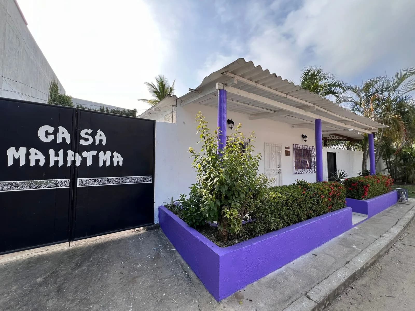 Fachada de Casa Mahatma en Palomino, con reja y muro morado