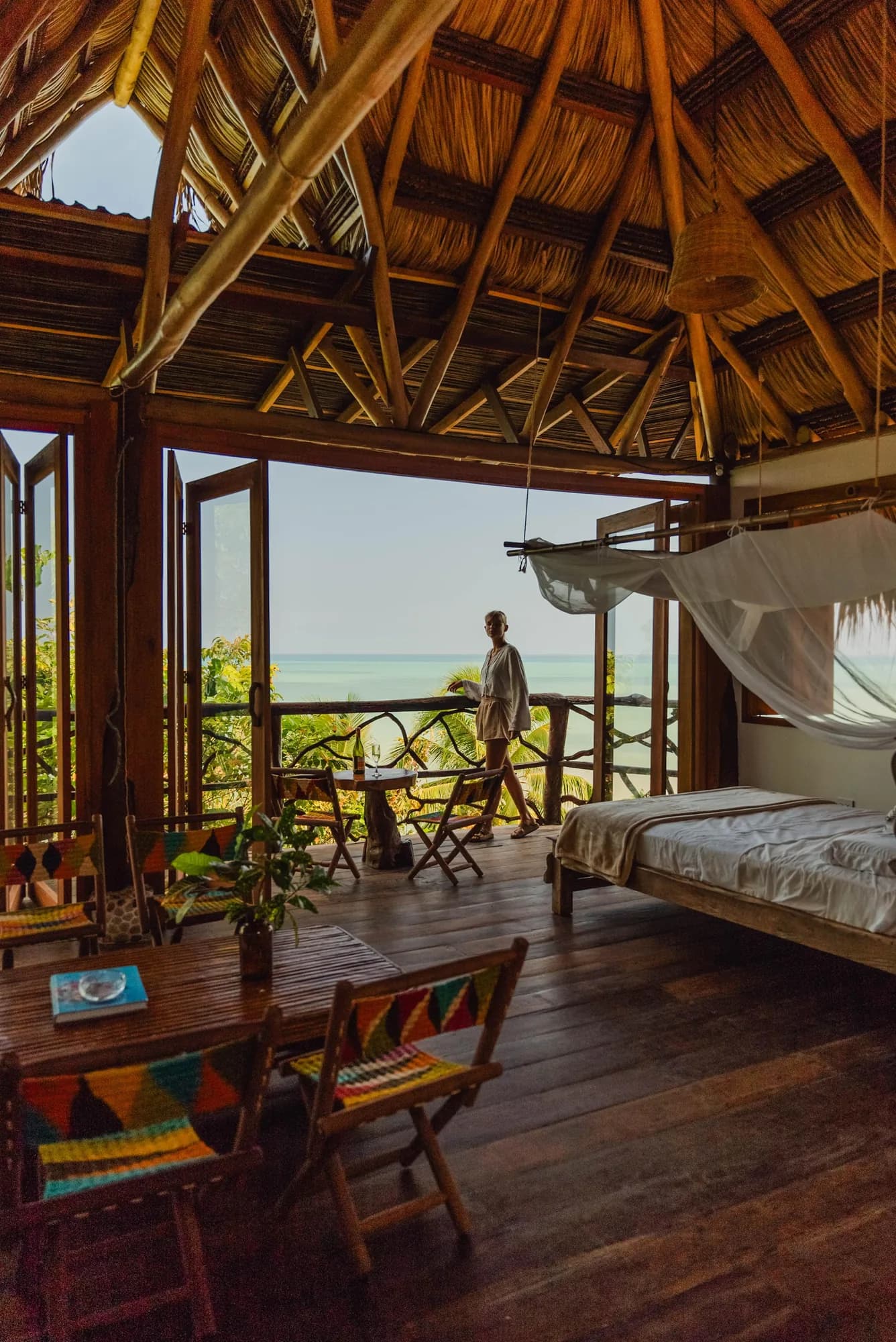 Interior de Morro Paraíso con cama con mosquitero y ventanales abiertos al Caribe