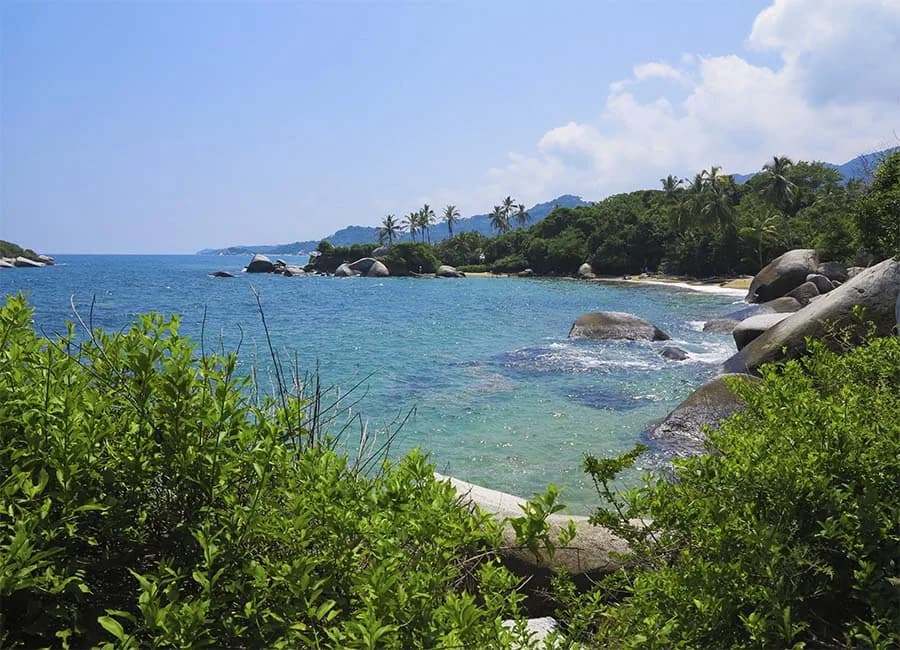 Bahía de agua turquesa del Parque Tayrona, entre selva y piedras